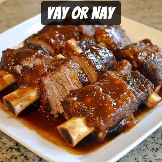 Slow cooker barbequed beef ribs served on a plate.