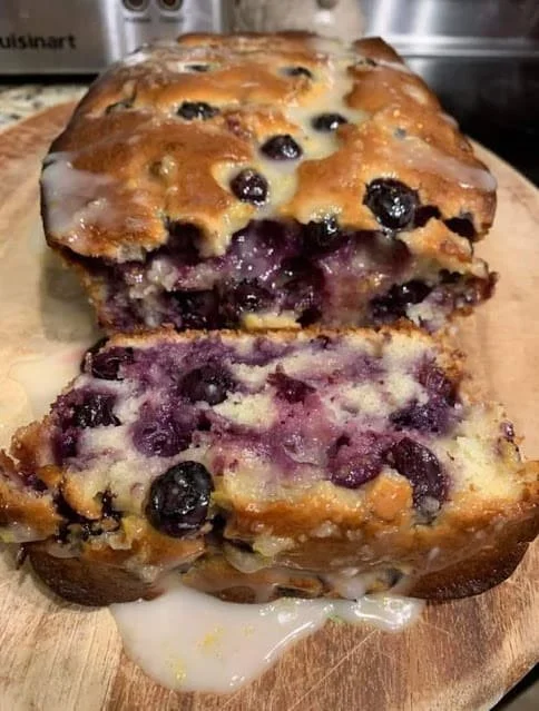Lemon Loaf and Berries Sliced lemon loaf cake topped with fresh berries on a wooden table